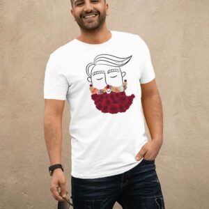 Un hombre sonriente está posando mientras usa una camiseta blanca con un diseño artístico en la parte delantera. El diseño minimalista en la camiseta muestra un dibujo de un rostro con una barba compuesta por flores de colores, combinando simplicidad con un toque creativo. El hombre lleva unos jeans oscuros y sostiene un par de gafas de sol en su mano izquierda, mientras posa relajado y natural contra un fondo neutro.